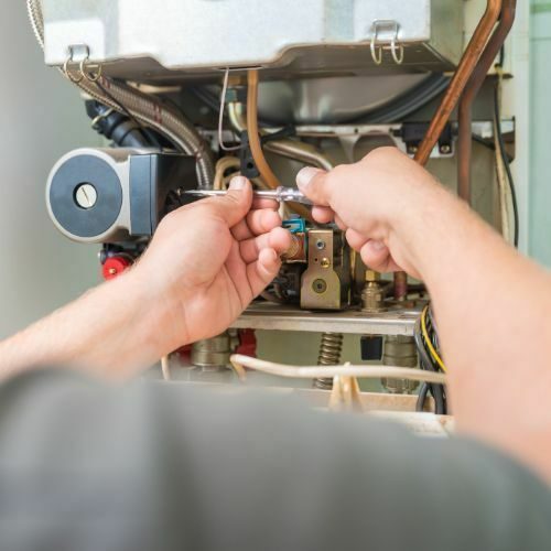 Performing routine maintenance on a furnace.