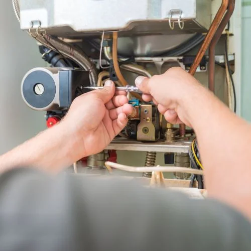 Performing routine maintenance on a furnace.